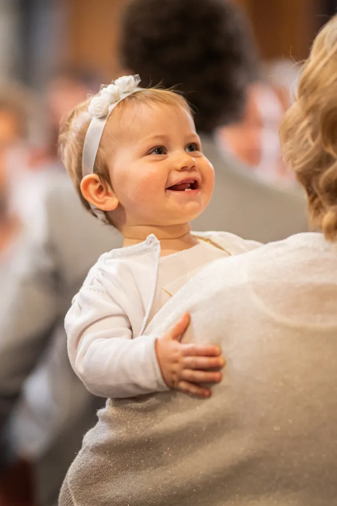 Une jolie petite fille sourit lors de son baptême à l'église de Draguignan