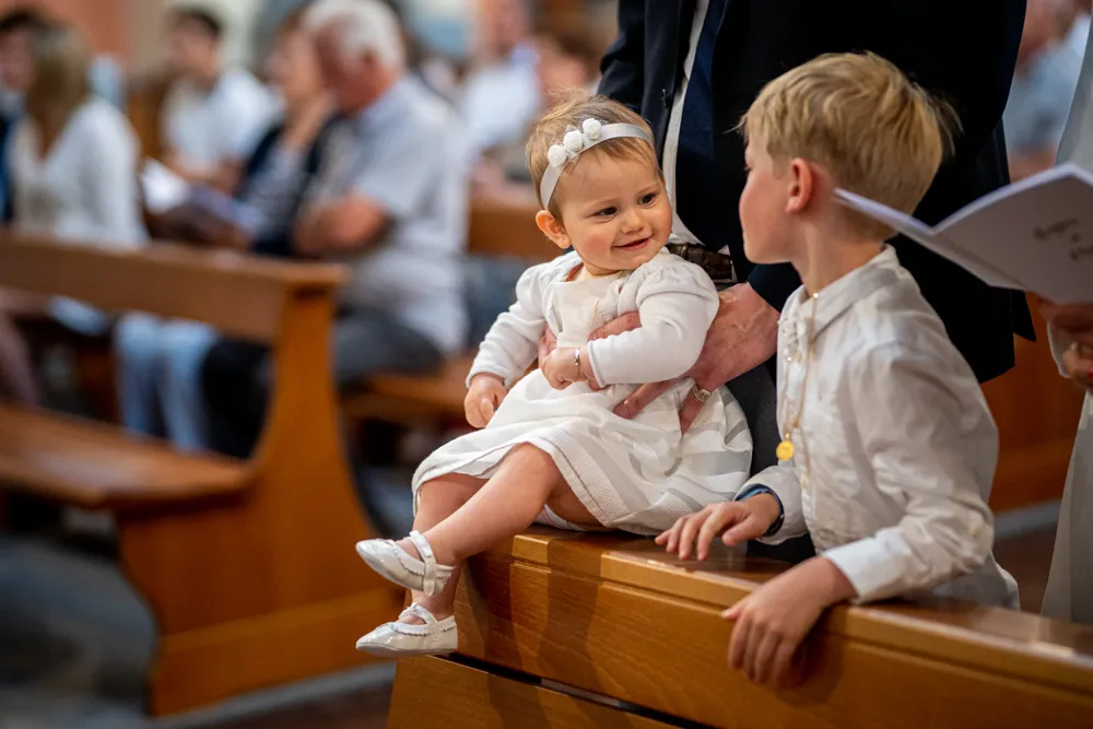 Une petite fille joue avec son grand frère à l'occasion de son baptême célébré en l'église de Draguignan. Photo réalisée lors du reportage photo