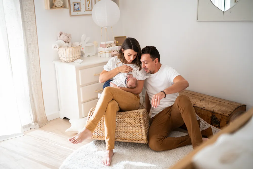 des jeunes parents admire leur bébé à l'occasion d'une séance photo famille à domicile à Draguignan