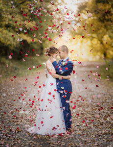 Un couple de jeunes mariés pose des pétales de rose leurs tombent dessus à Draguignan