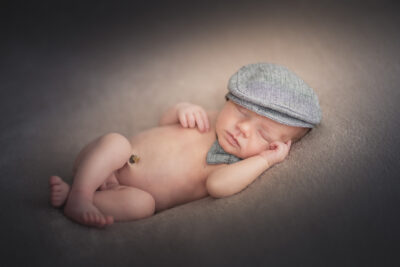 Bébé dort avec sa casquette pour ses photos de bébé