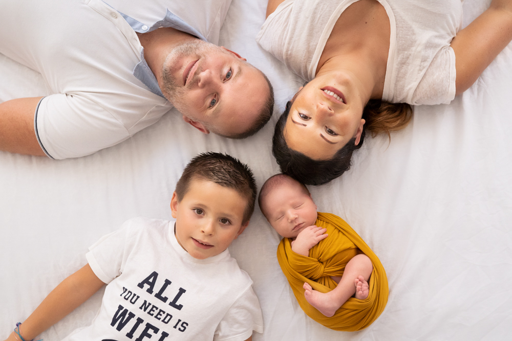 famille pose allongée avec le bébé pour sa séance photo à Draguignan