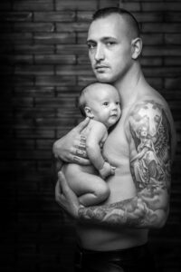 nouveau-ne-bebe-draguignan-68 papa pose avec son bébé dans les bras au studio photo de Draguignan