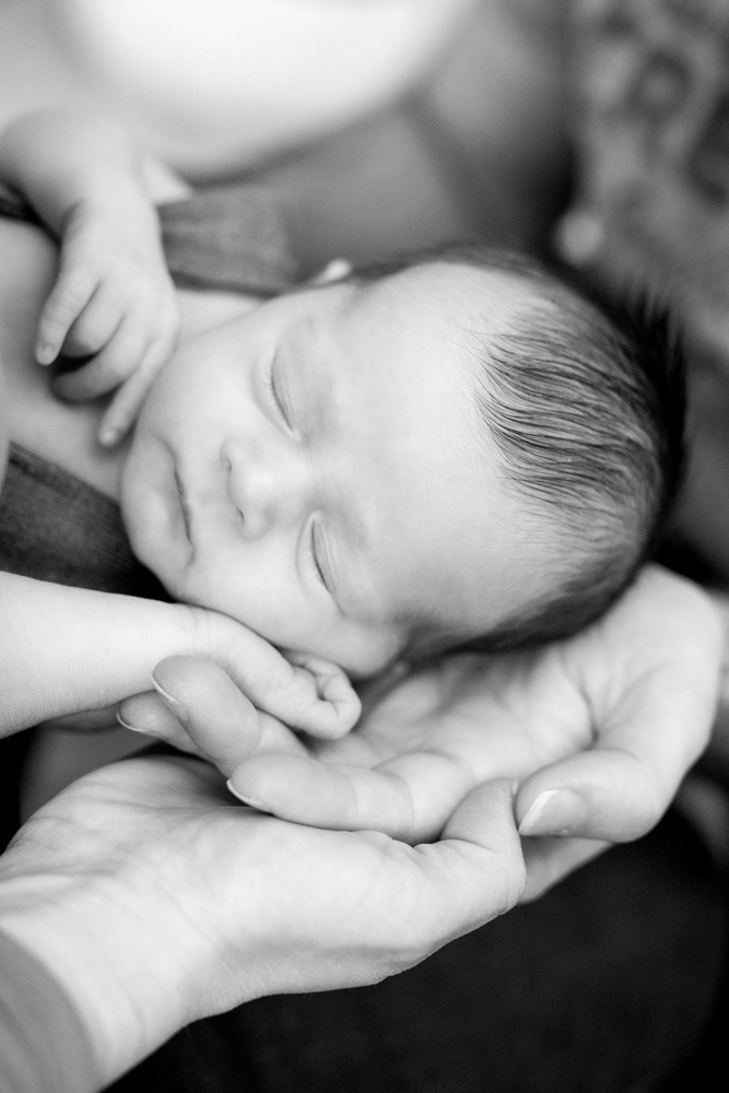 bébé endormi appuyé sur les mains de ses parents lors de sa séance nouveau-né à Draguignan
