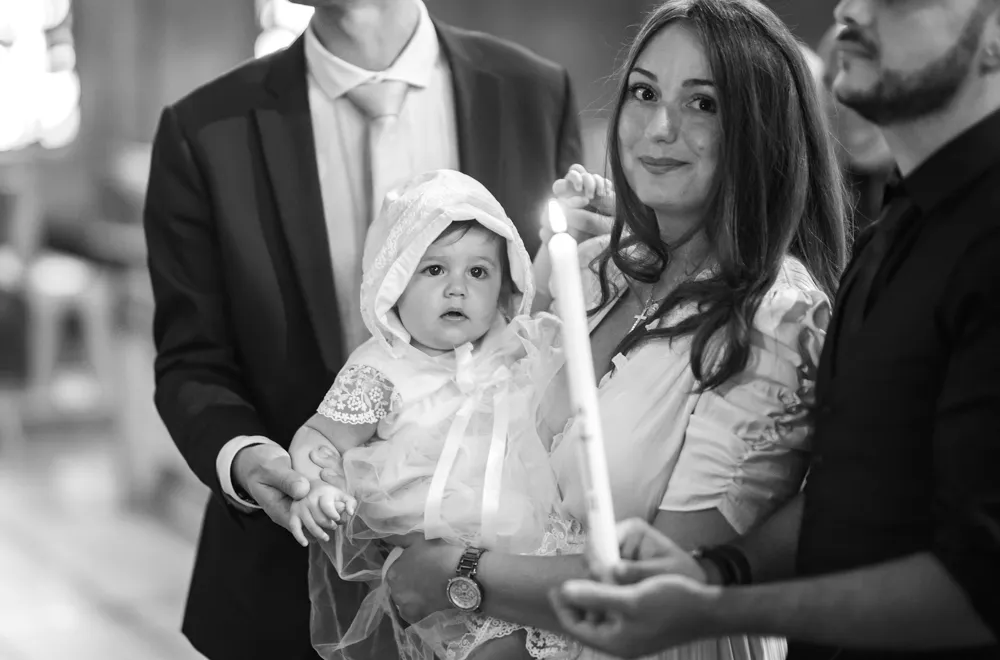 Baptême célébré dans le Var une petit fille regarde le cierge