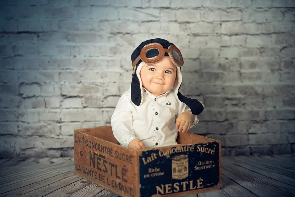 Un petit garçon pose dans une caisse en bois pour une séance photo à Draguignan