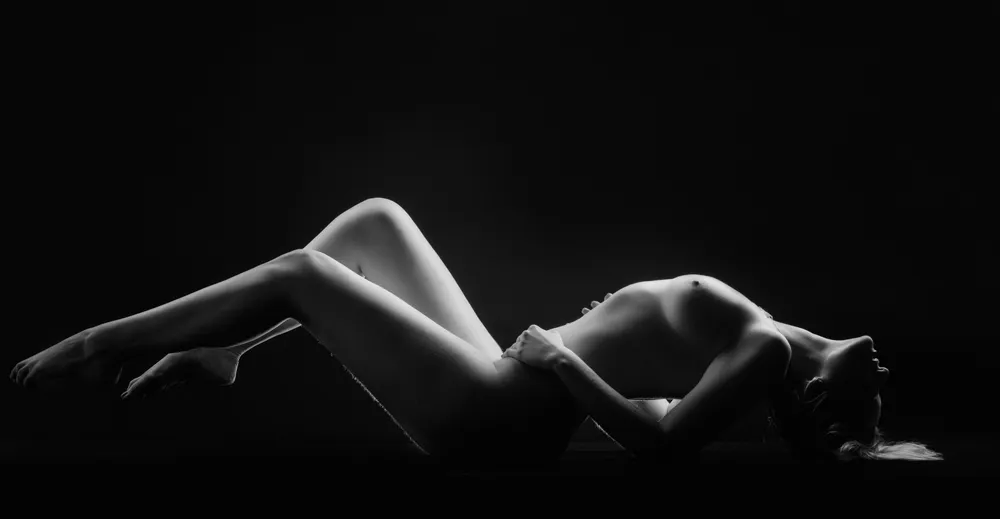 Photo noir et blanc d'une femme nue allongée sur le dos