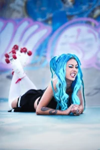projet coiffure à Draguignan une jeune femme avec des cheveux bleu pose allongée sur le ventre avec des patins à roulette au pied dans le steak park de Draguignan
